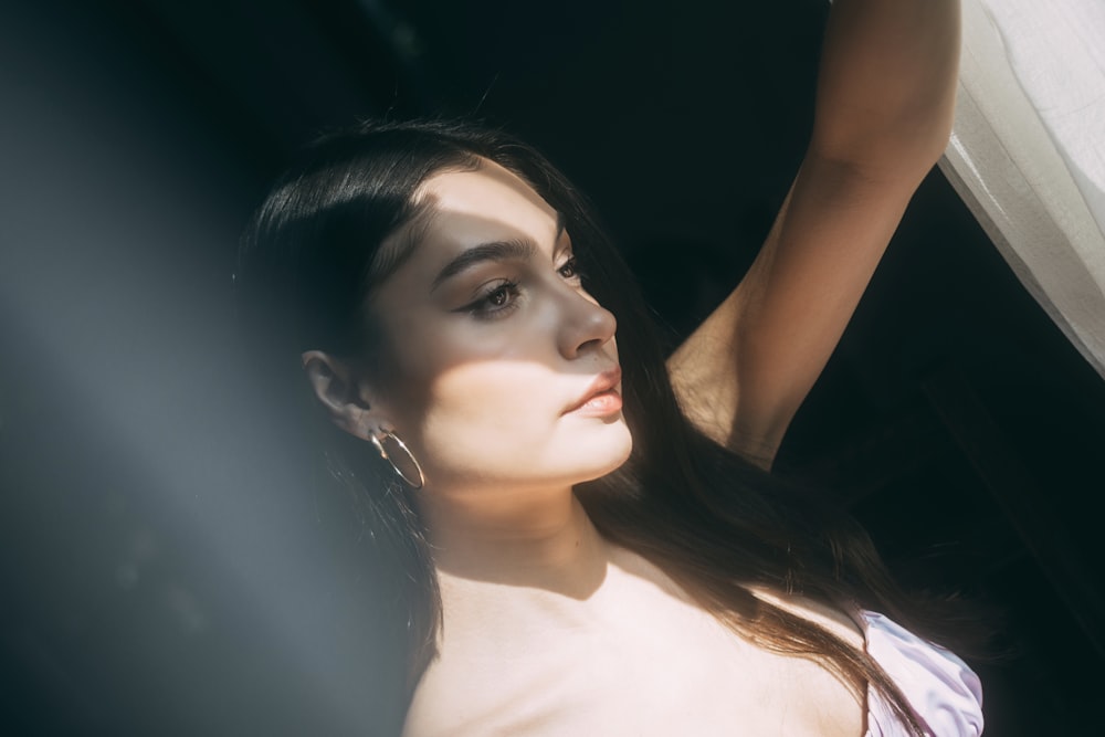 a woman in a white dress looking out a window