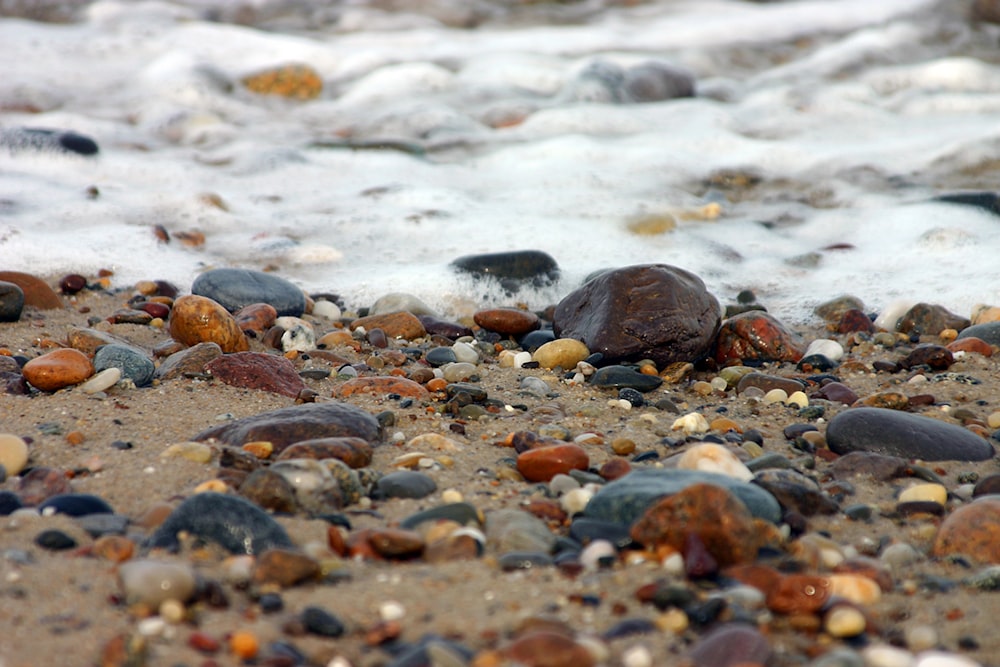 a close up of rocks and water on a beach