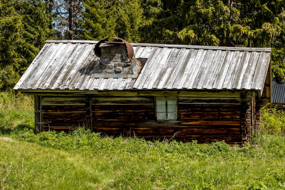 an old log cabin with a rusty roof