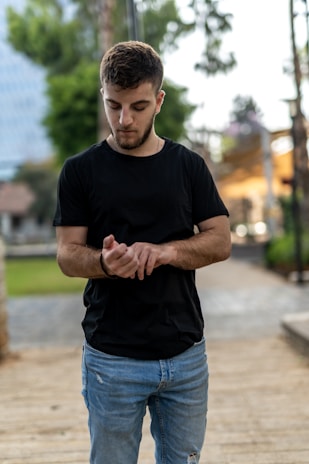A young professional glancing at their Urbantick watch while walking through a busy city street.