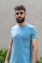 a man with a beard wearing sunglasses and a blue shirt