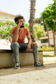 a man sitting on a bench talking on a cell phone