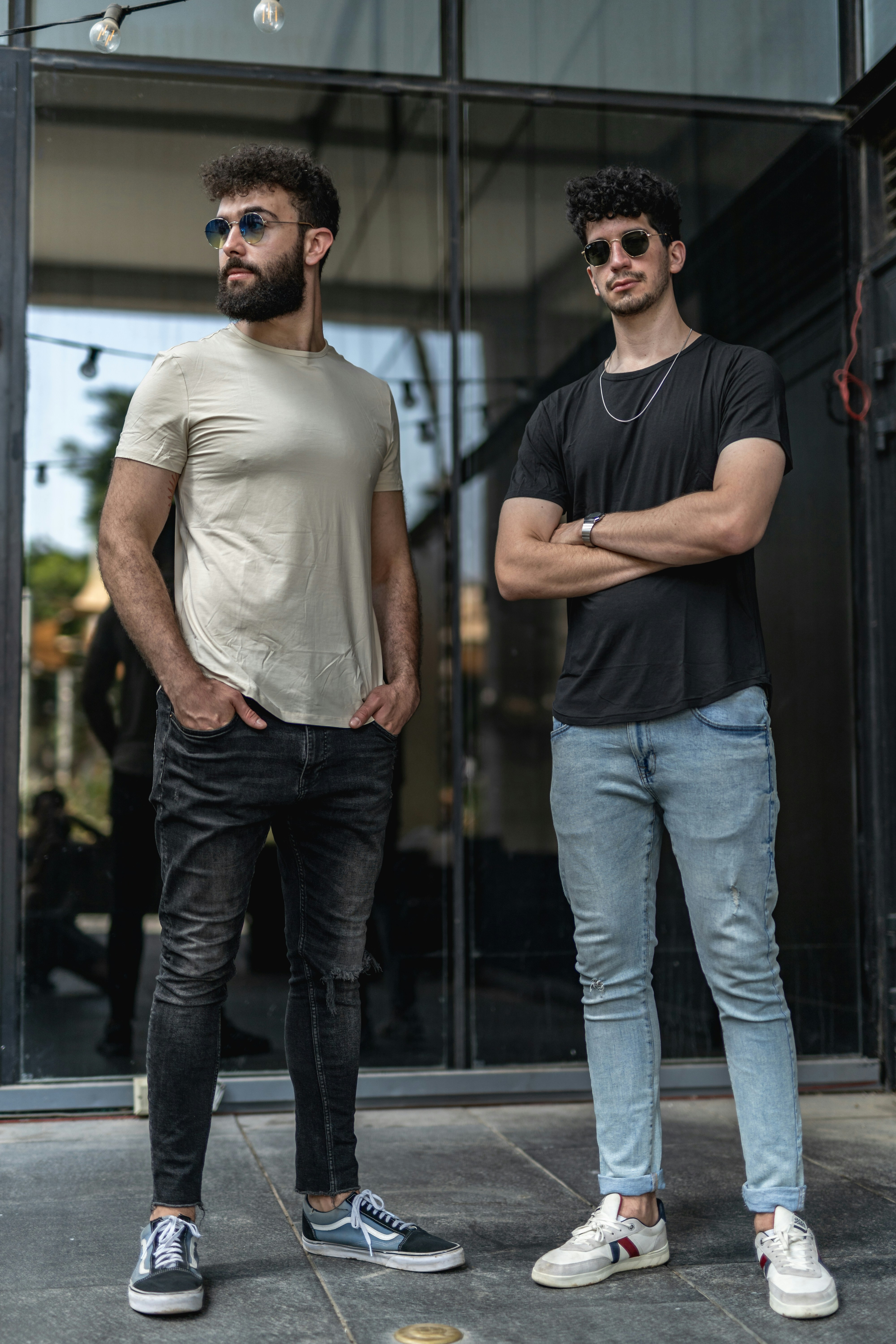 Two men standing next to each other in front of a building photo – Free ...
