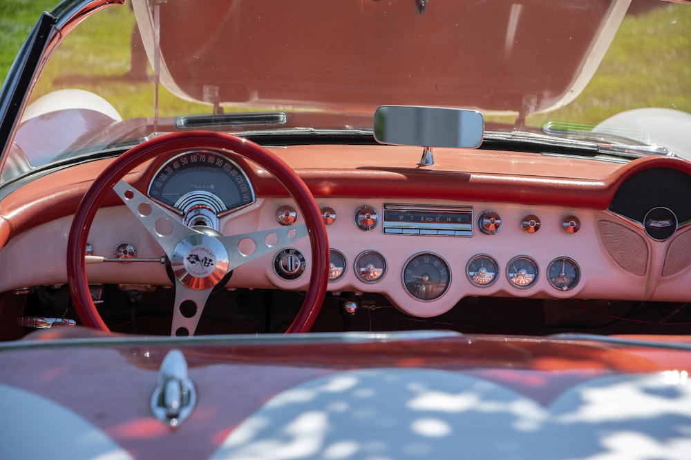 the dashboard of a classic car with a pink interior