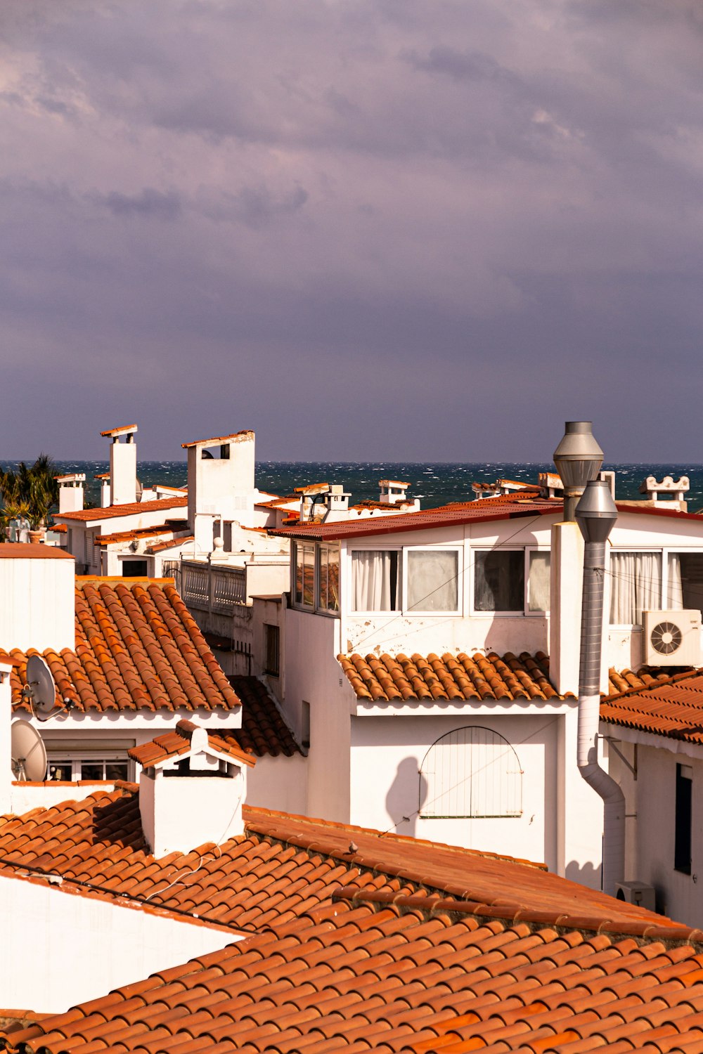 a row of white buildings with red tiled roofs