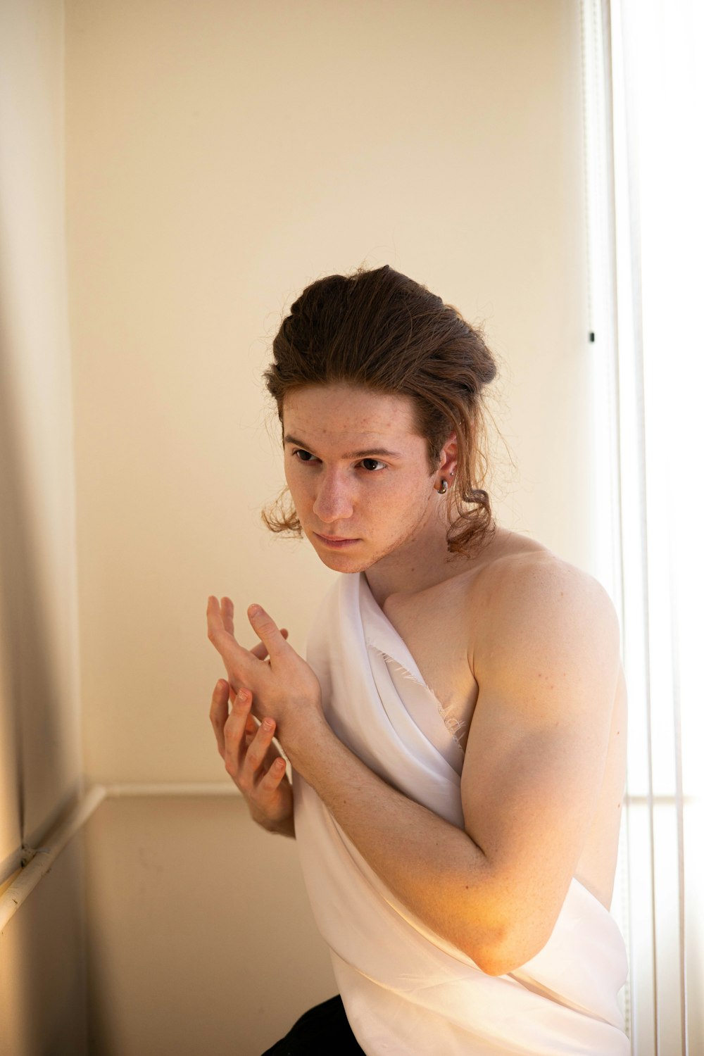 a woman in a white top sitting on a chair