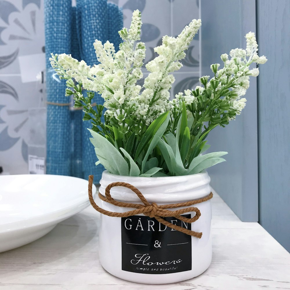 a white jar with some white flowers in it