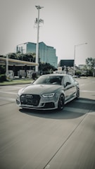 An influencer filming a dynamic video review of a new car model on city streets.