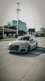 A sleek car on a city road symbolizing motor insurance protection.