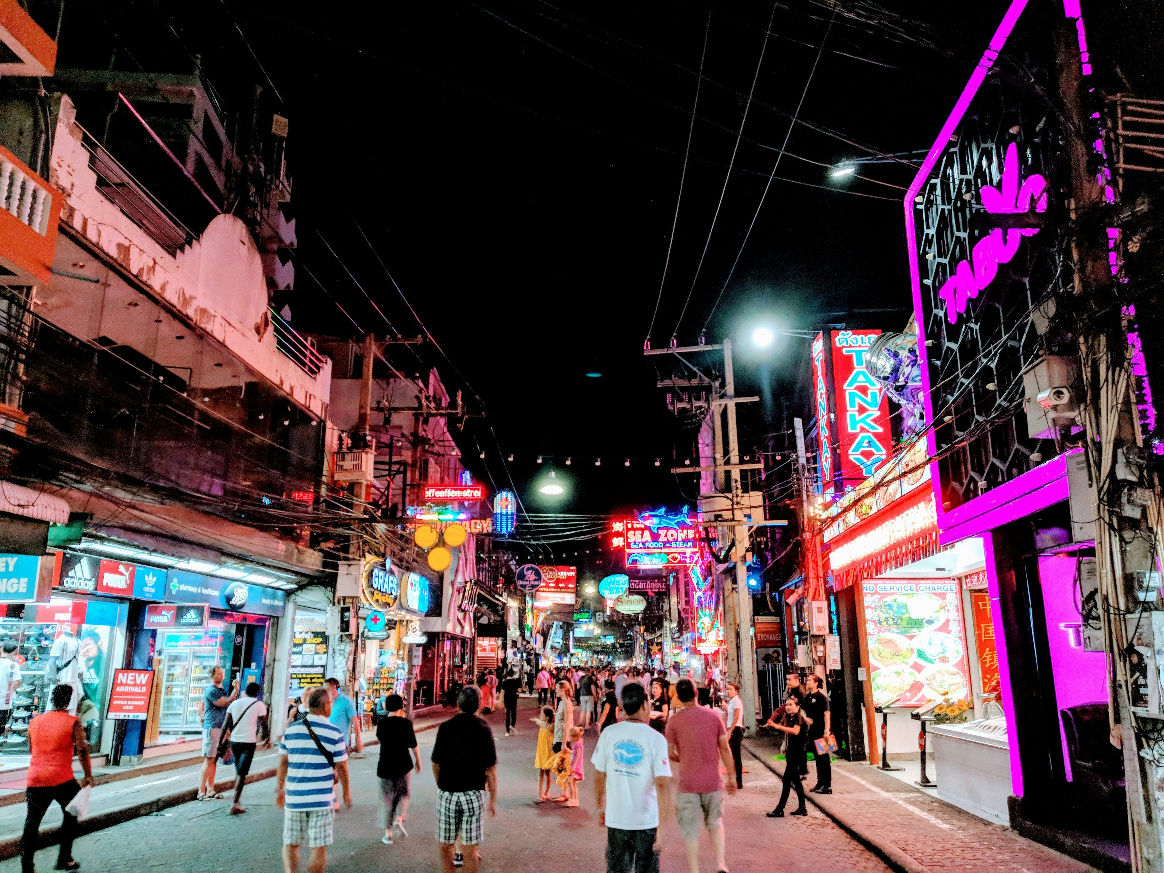 a group of people walking down a street at night