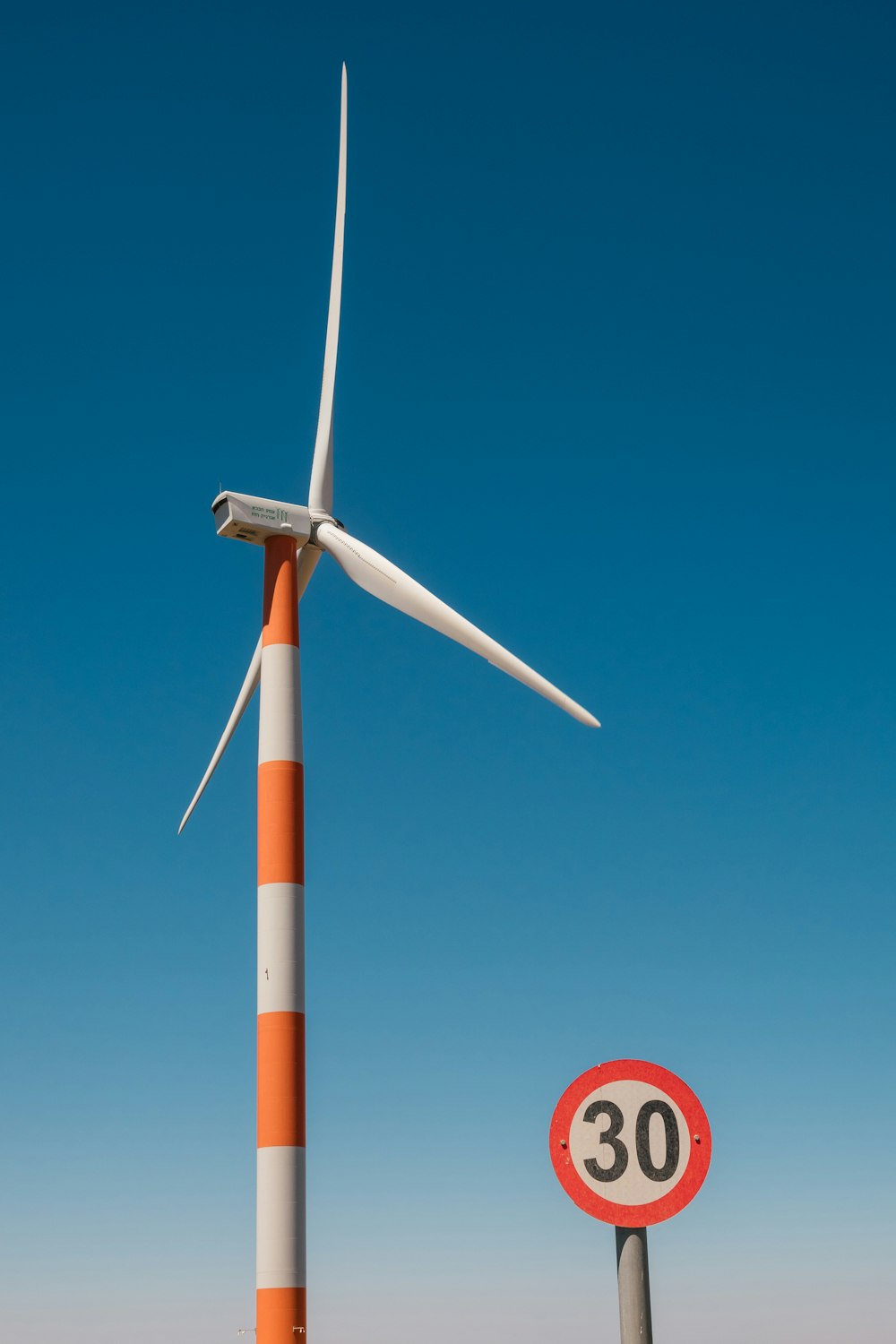 a wind turbine next to a speed limit sign