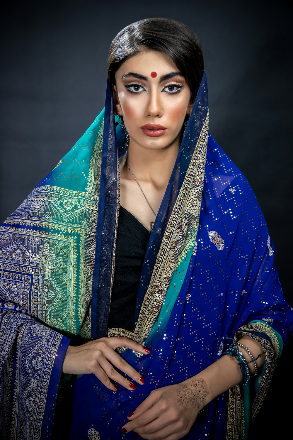 a woman wearing a blue and green sari