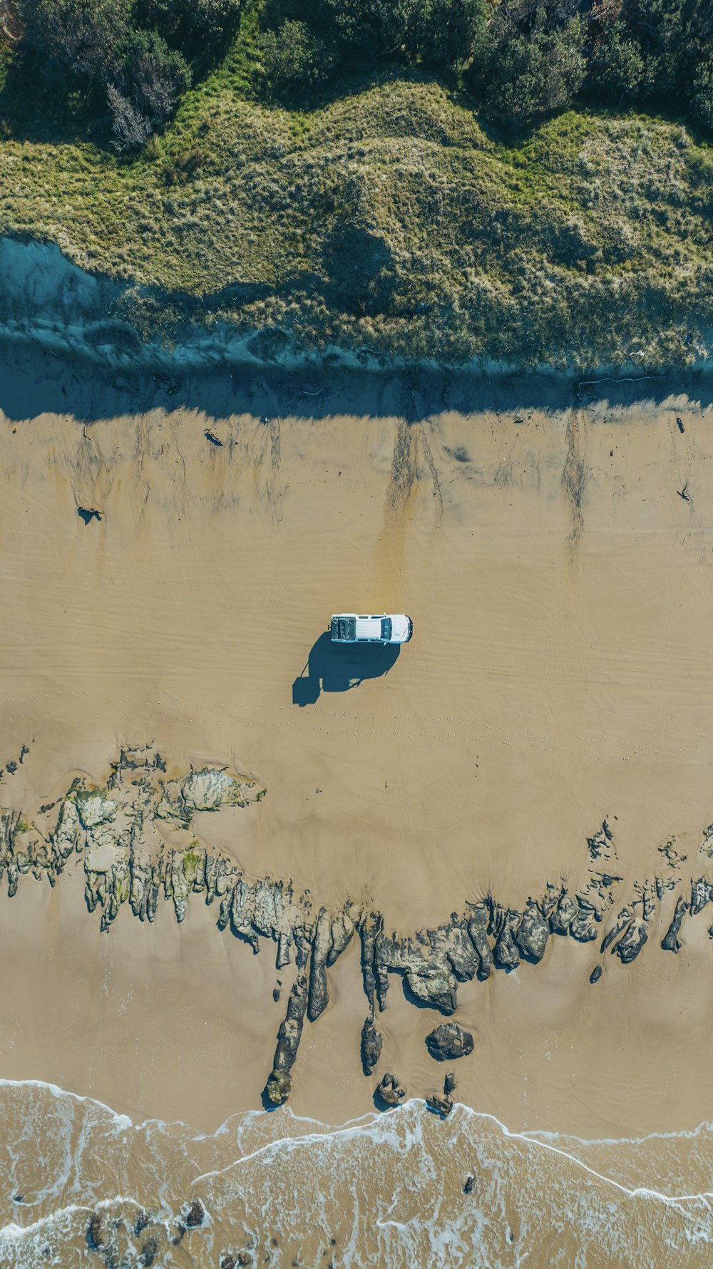 an aerial view of a van parked on the beach