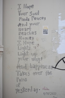 a white wall with graffiti written on it