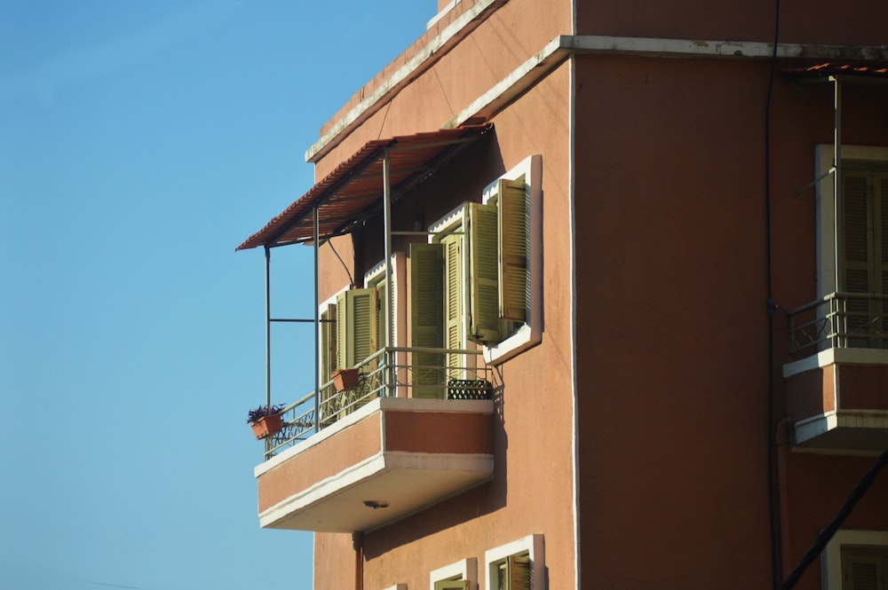 a tall brown building with a balcony and balconies