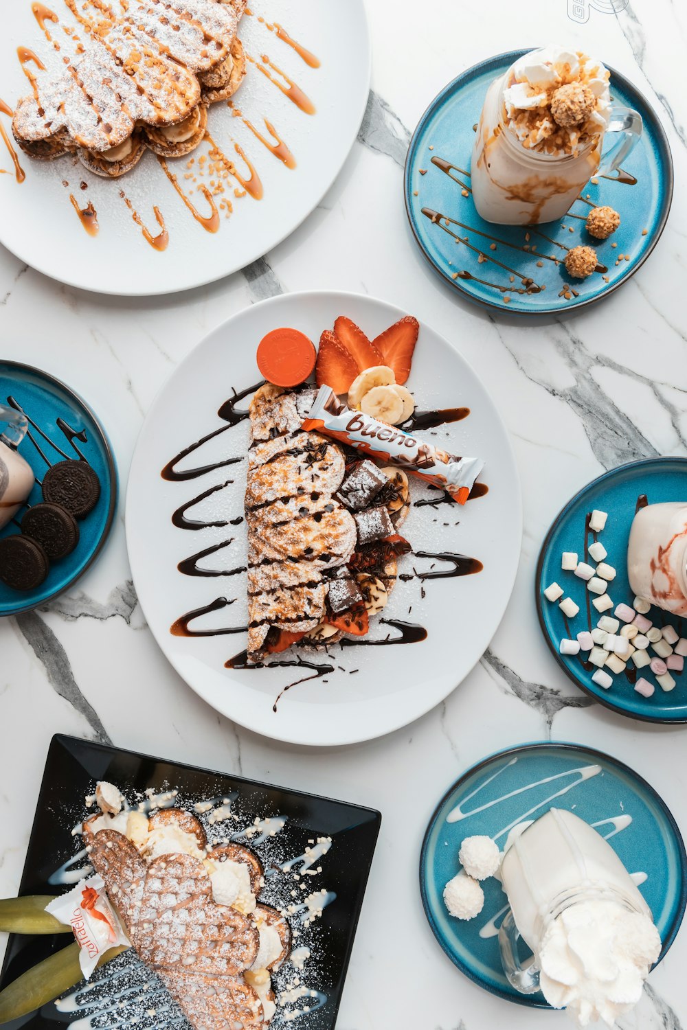 a table topped with plates of food and desserts