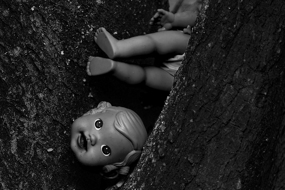 Une poupée est allongée dans un arbre