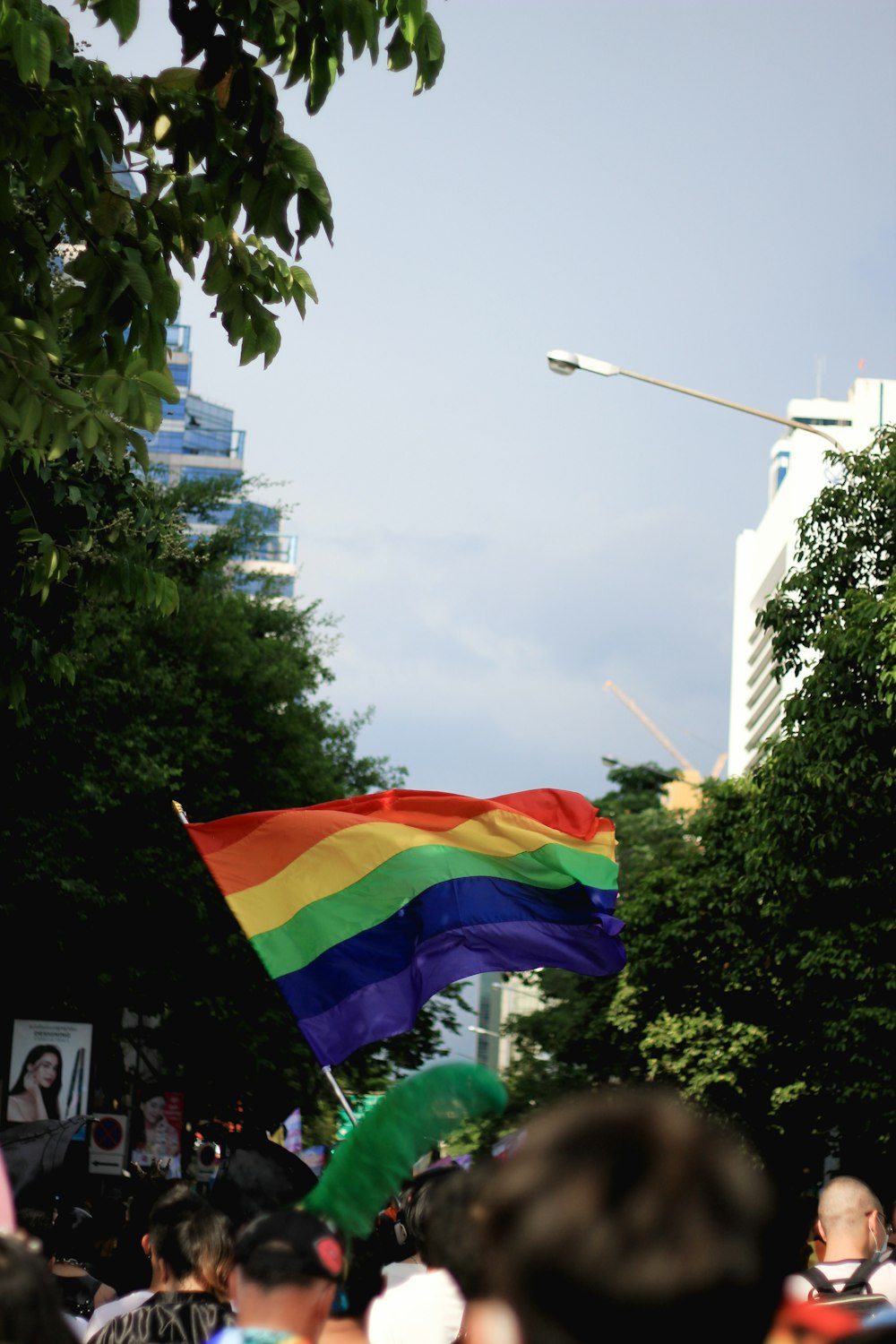 a rainbow flag flying in a crowd of people