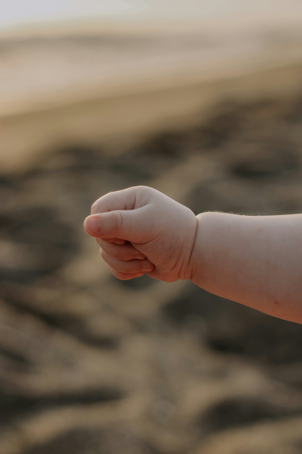 a baby's hand reaching for something in the air