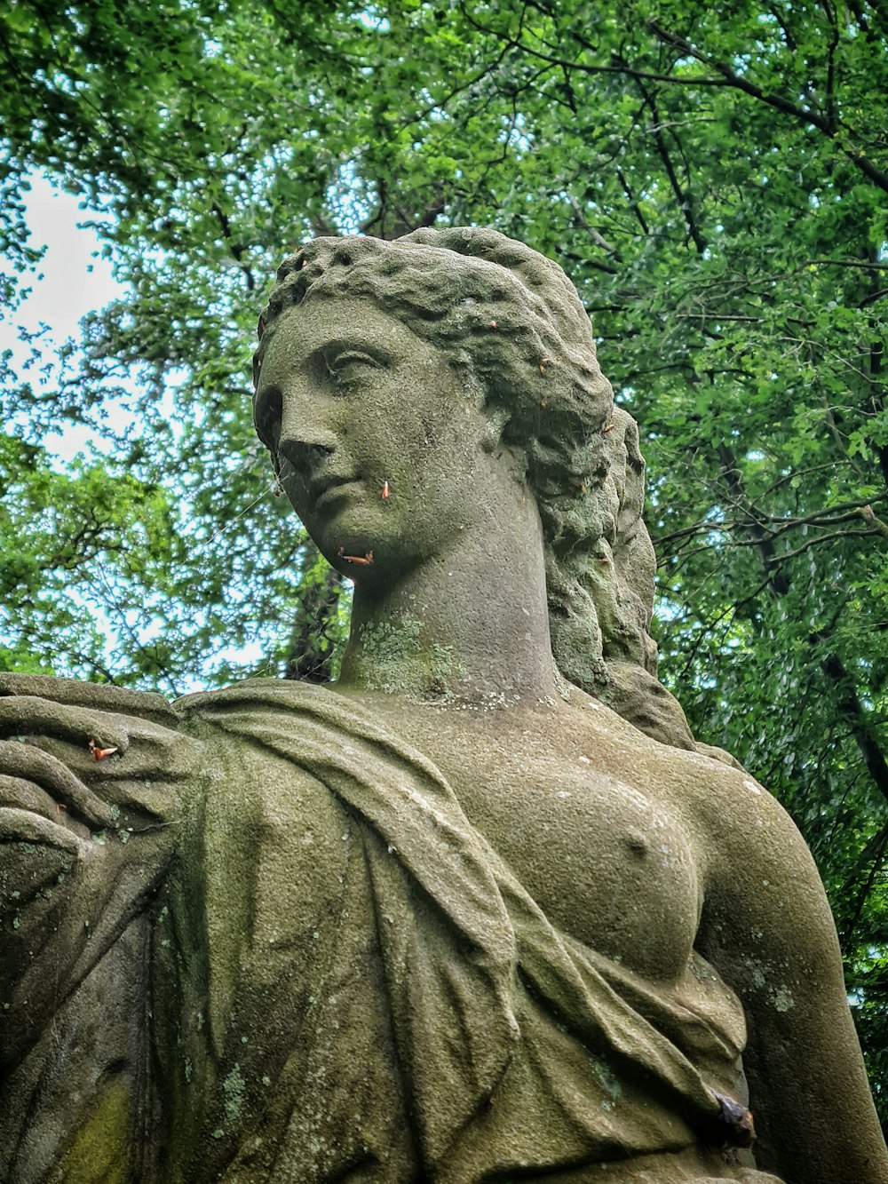 une statue d’une femme tenant un oiseau dans sa main