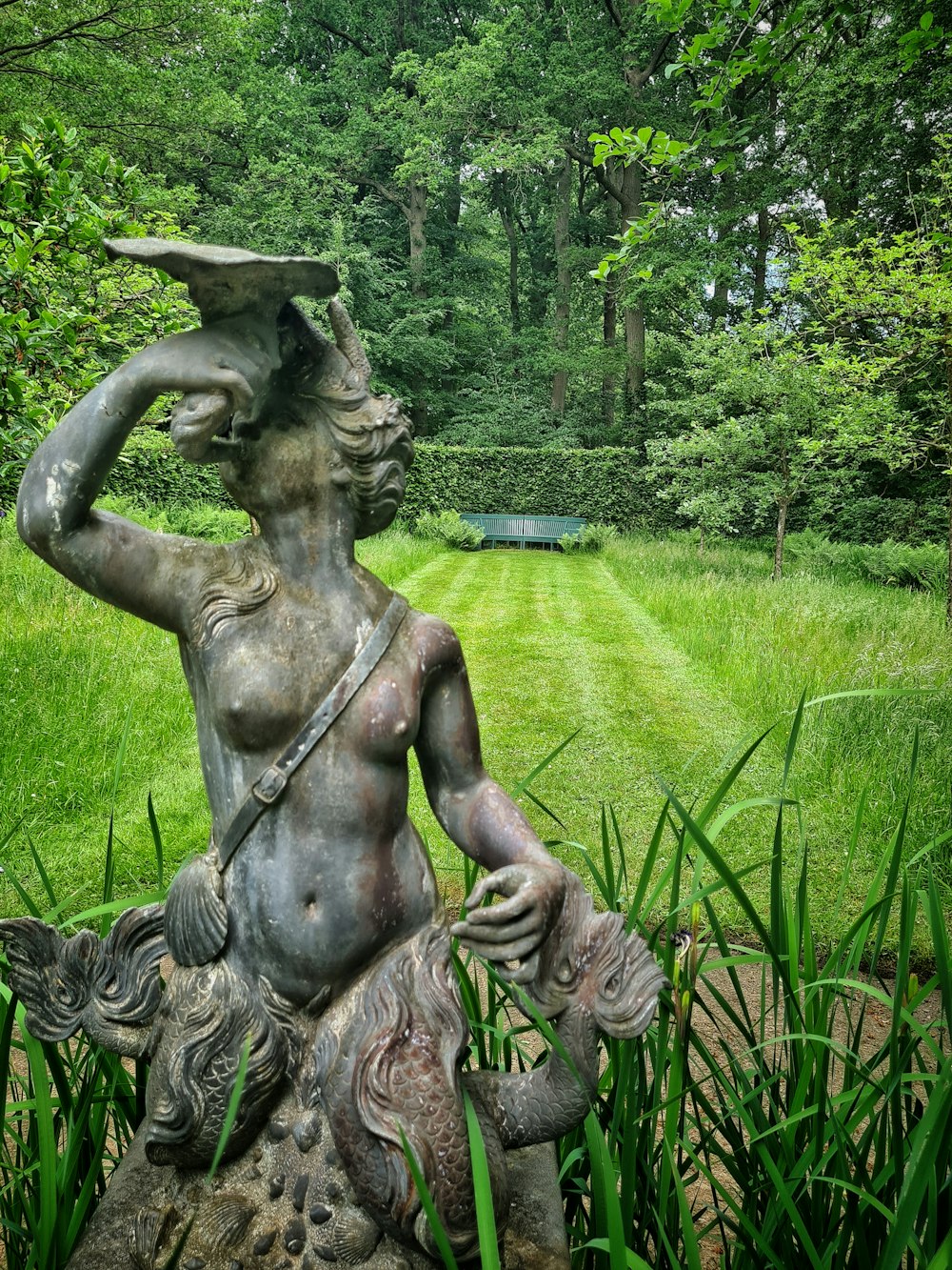 une statue d’une femme tenant un oiseau sur sa tête