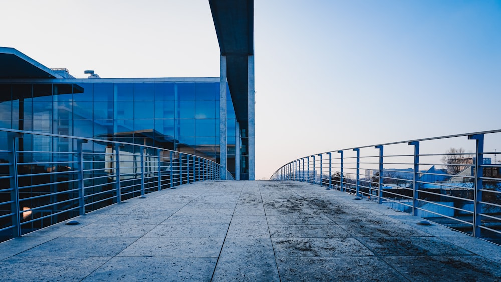 a walkway leading to a building with a large glass window