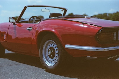 A shiny convertible cruising down an open Texas highway under a bright blue sky.