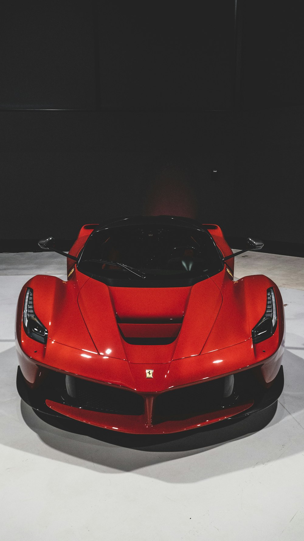 a red sports car sitting on top of a white floor