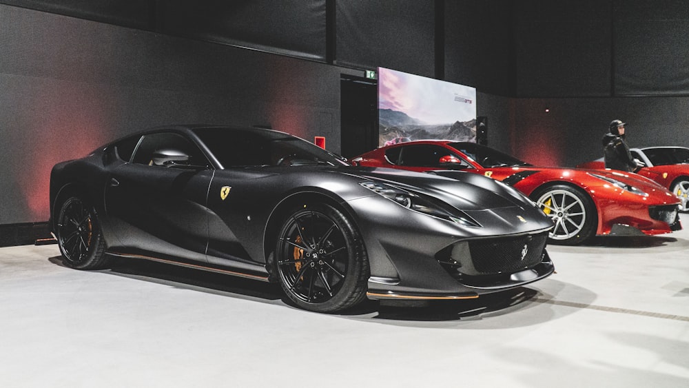 a black sports car and a red sports car on display