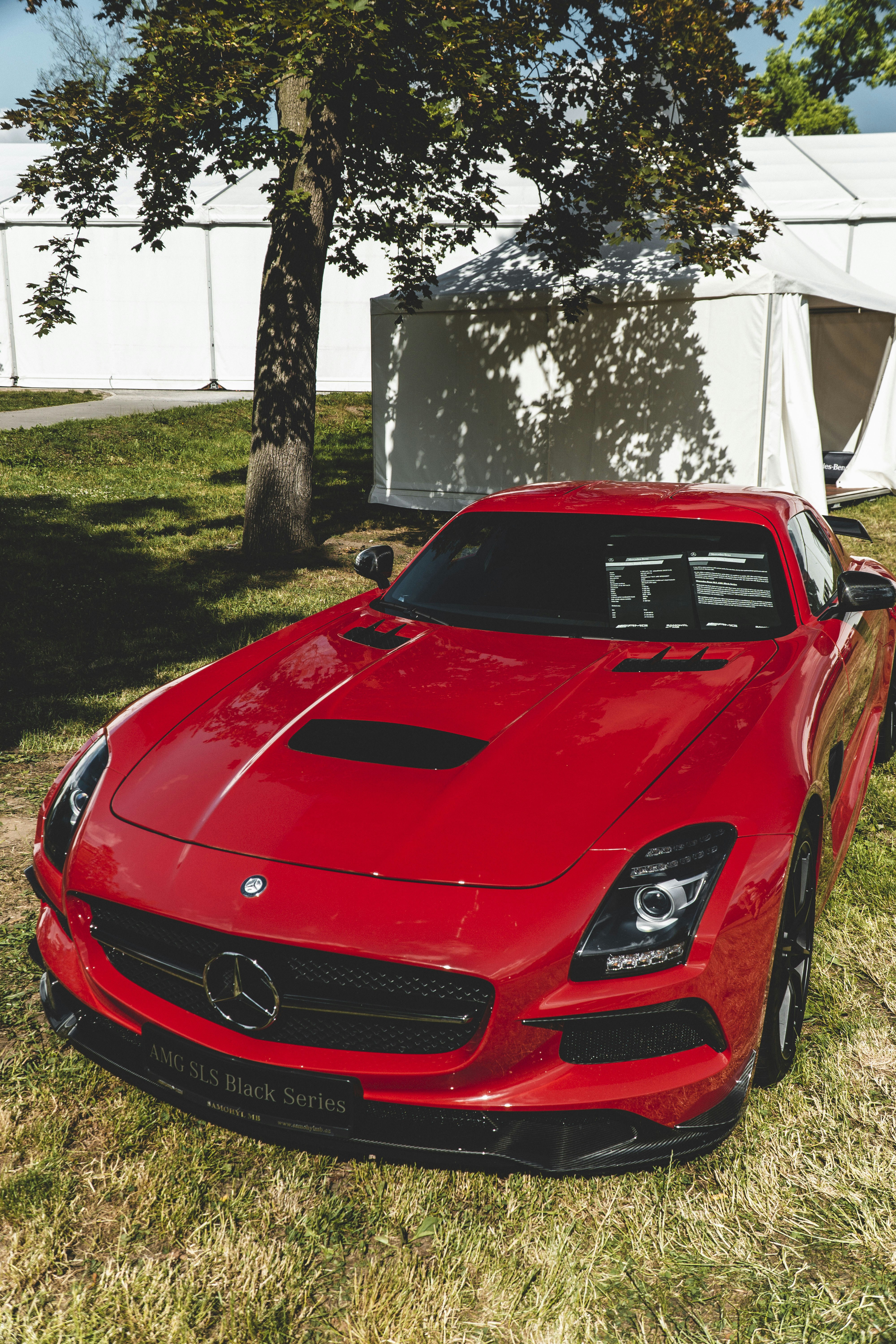 Un coche deportivo rojo estacionado en la hierba