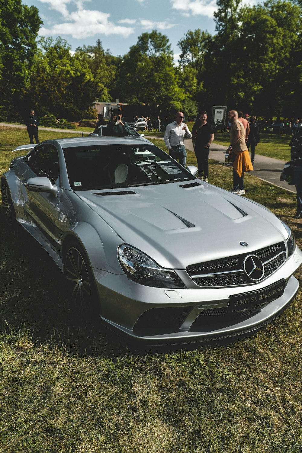 a silver car parked on top of a lush green field