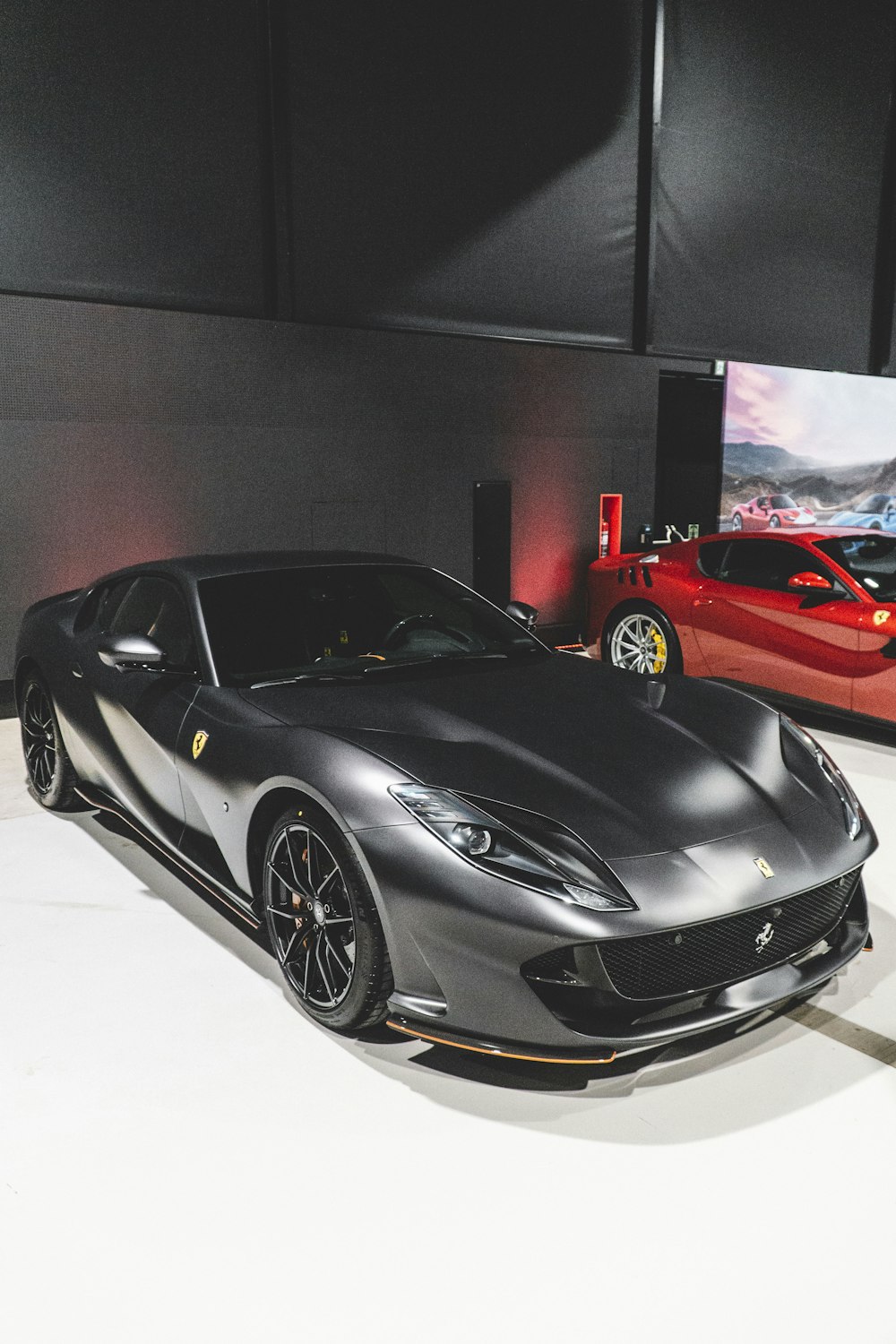 a silver sports car parked next to a red sports car