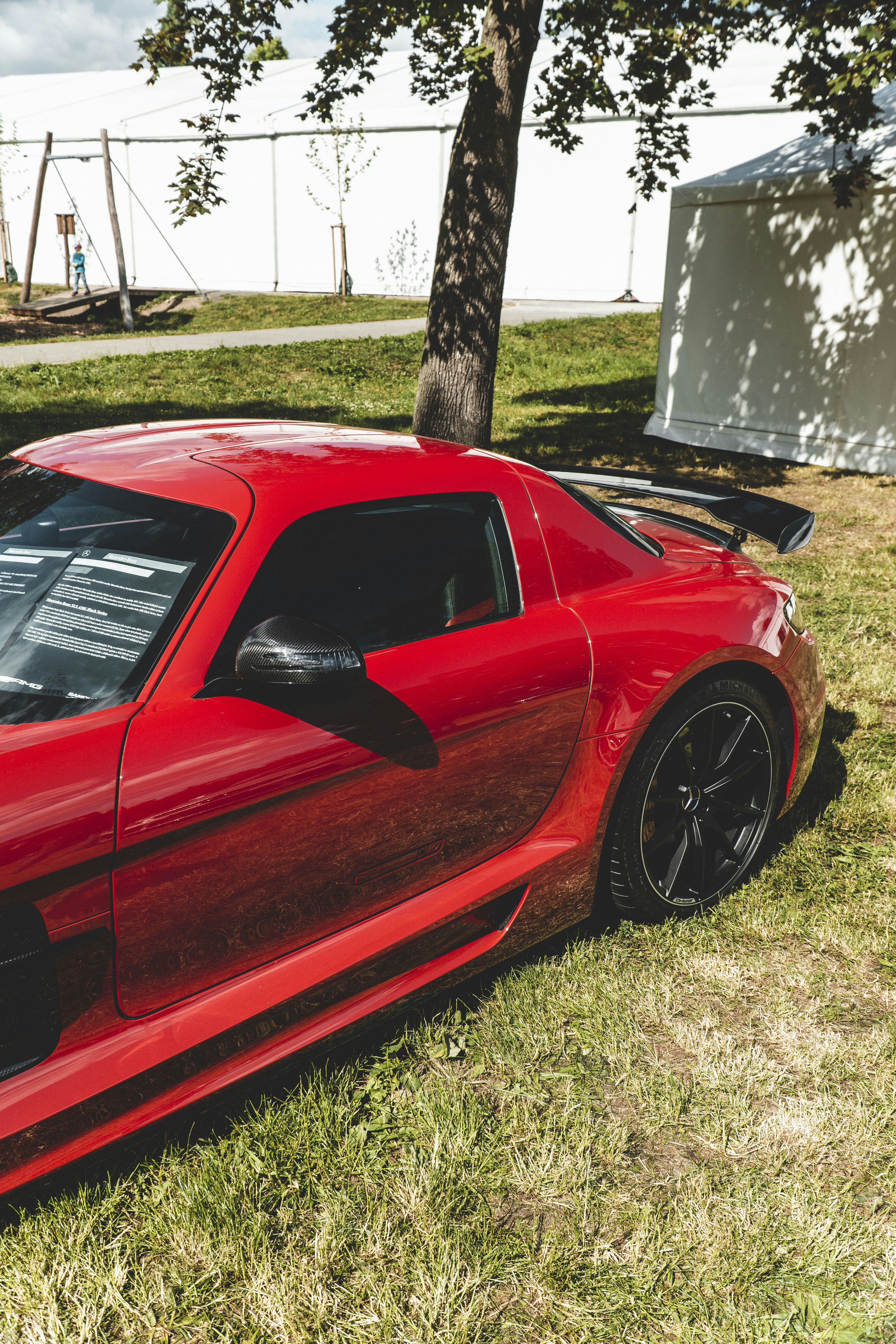 Un coche deportivo rojo estacionado en la hierba