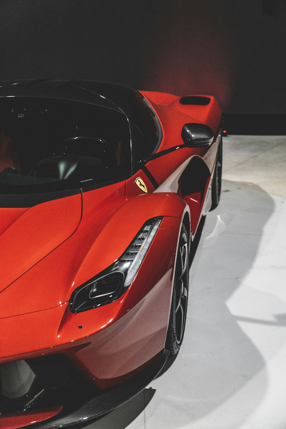 a close up of a red sports car on display