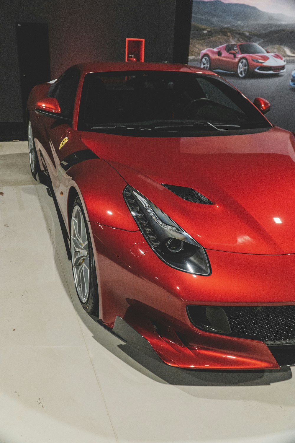a red sports car on display in a showroom