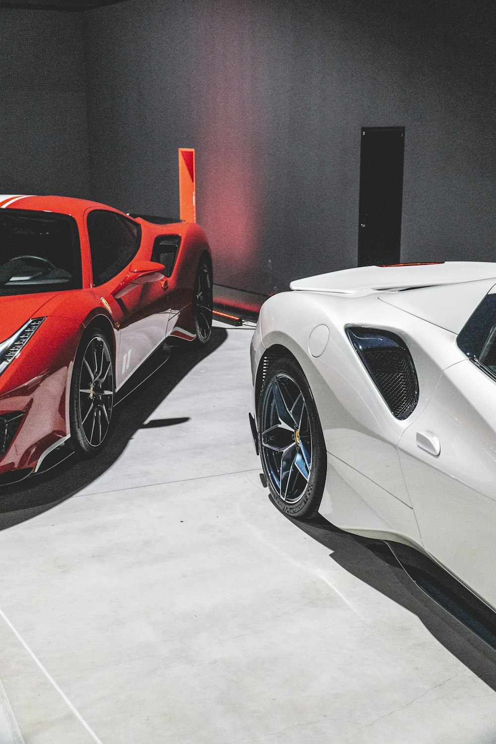 two white and red sports cars in a showroom