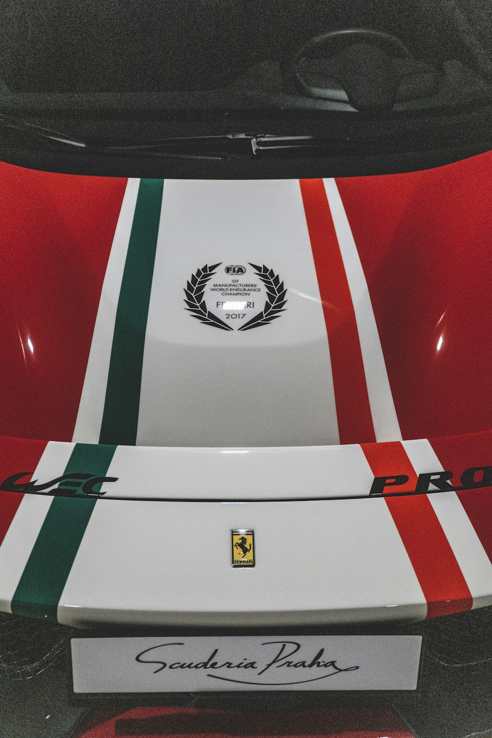 a red, white and green sports car with a logo on it