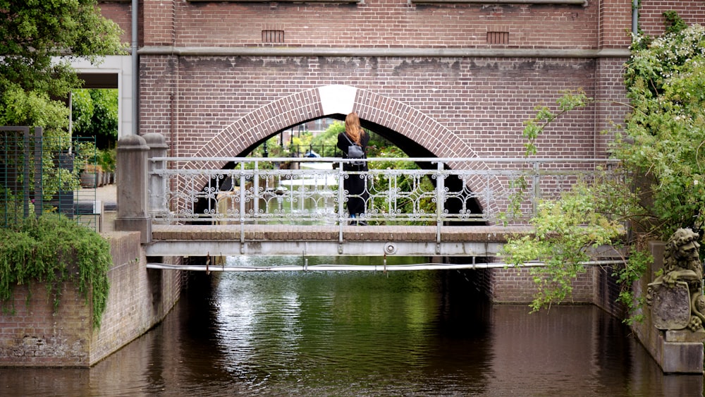 a man standing on a bridge over a river