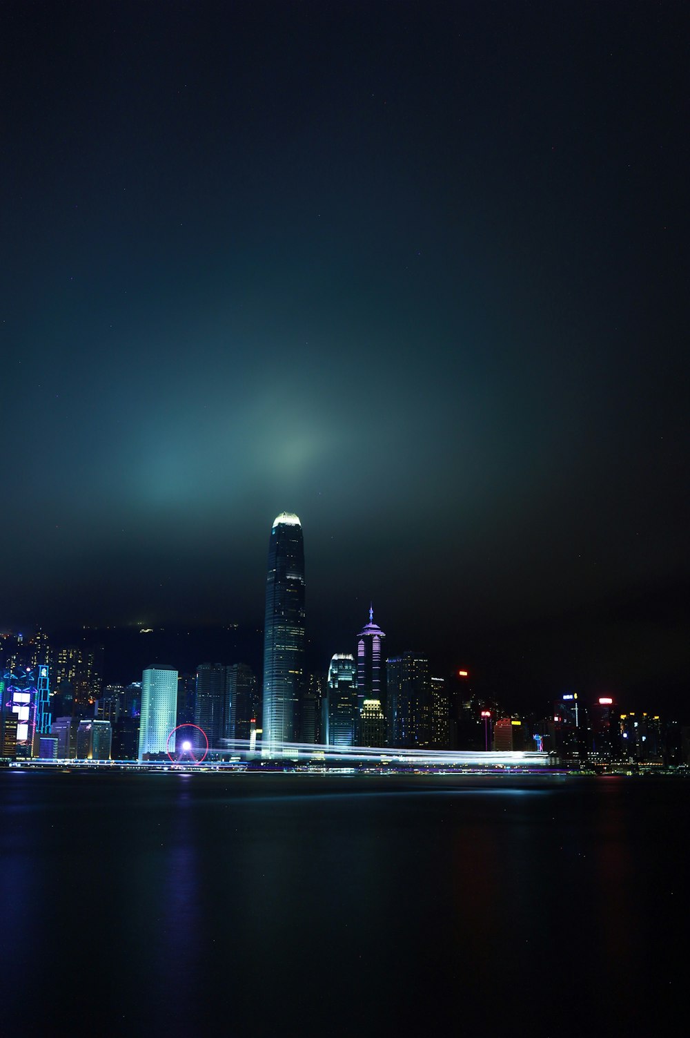 a city skyline at night with lights reflecting off the water