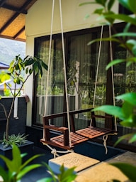 a wooden swing sitting next to a window
