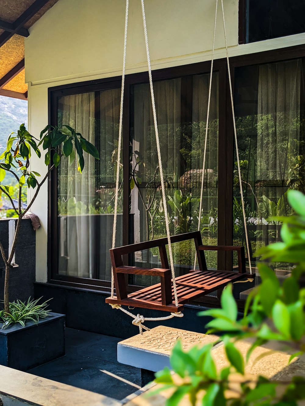 a wooden swing hanging from the side of a house