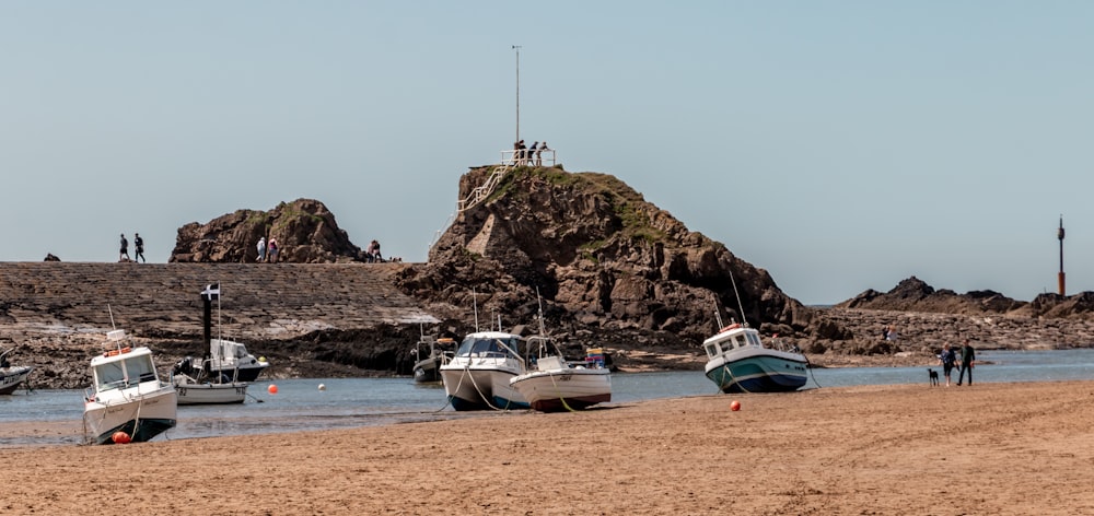 a group of boats sitting on top of a sandy beach