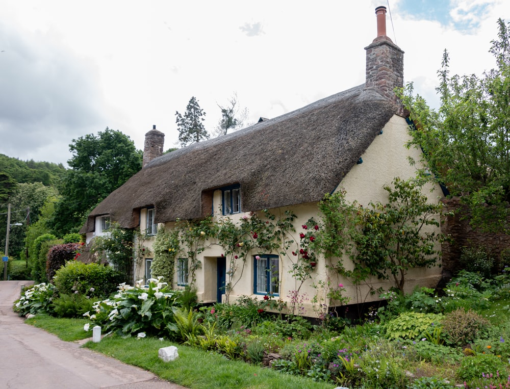 a house with a thatched roof surrounded by greenery