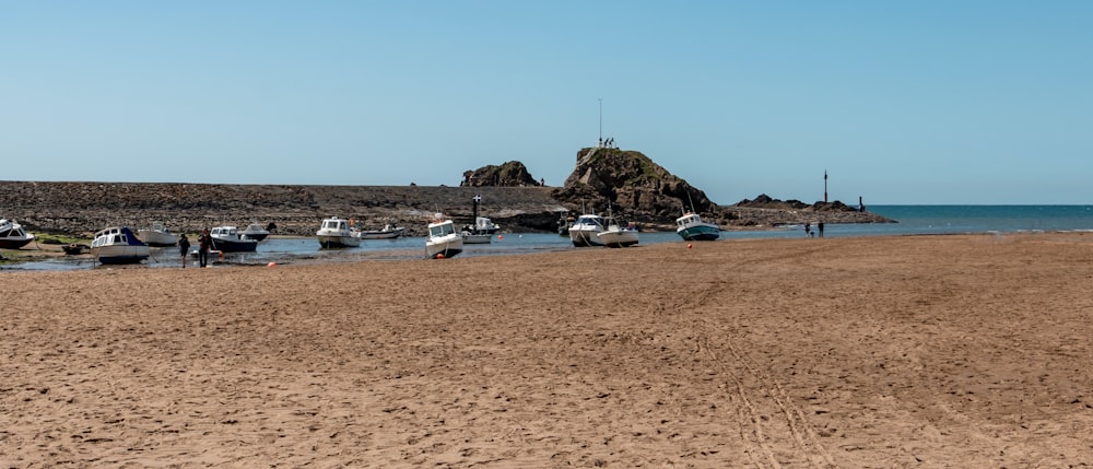 a group of boats sitting on top of a sandy beach