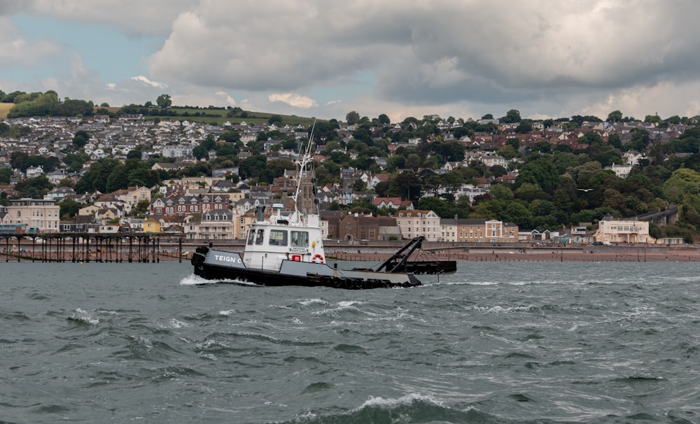 a tug boat in a body of water with a city in the background