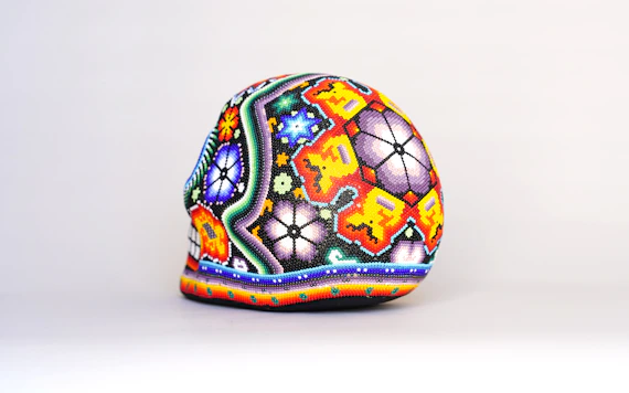 a colorful painted egg sitting on top of a white table