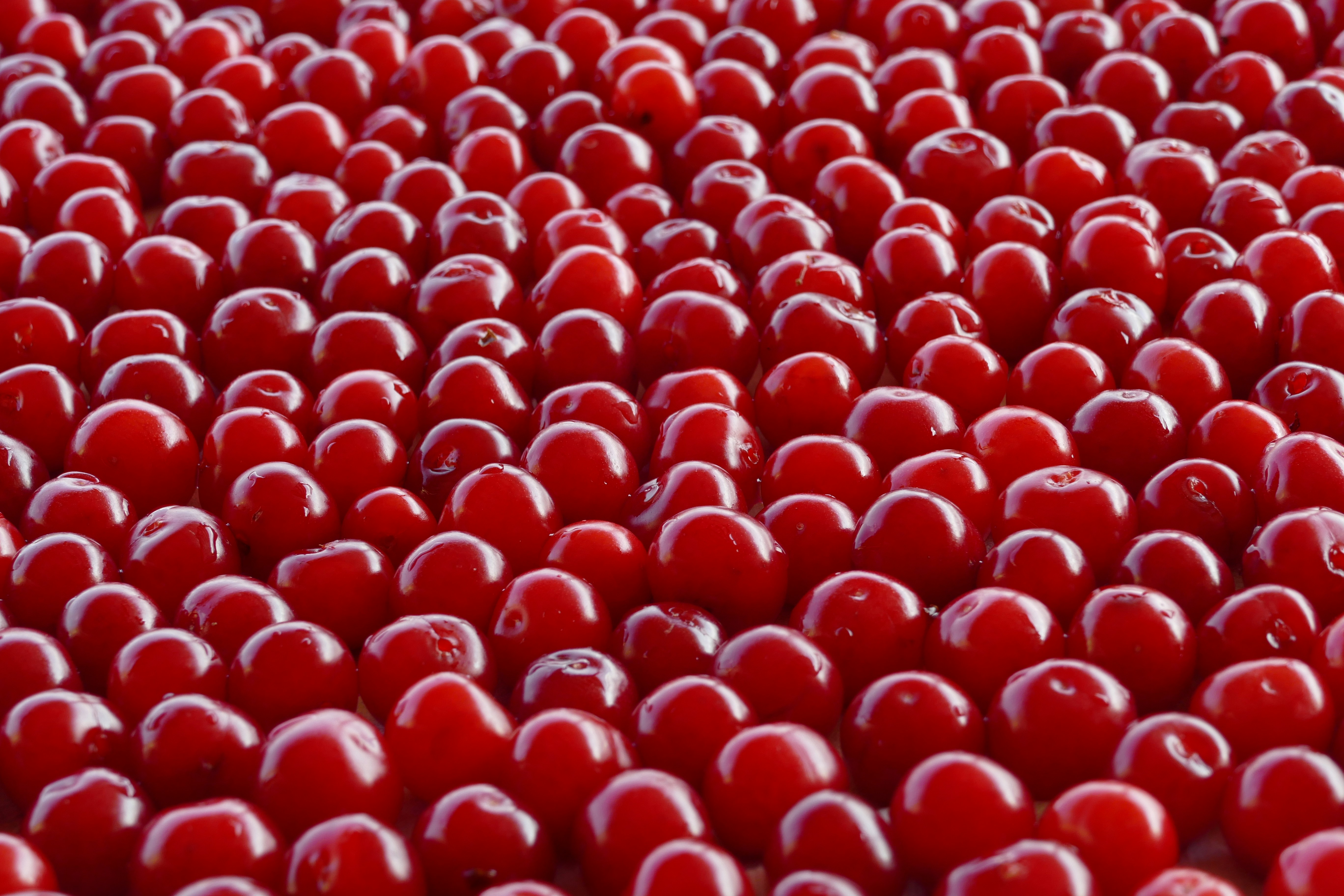 a large group of red berries sitting on top of a table
