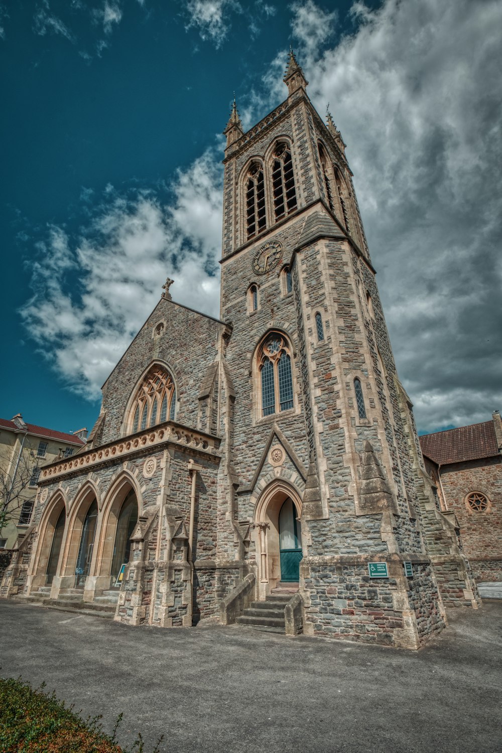 a large stone church with a steeple on a cloudy day