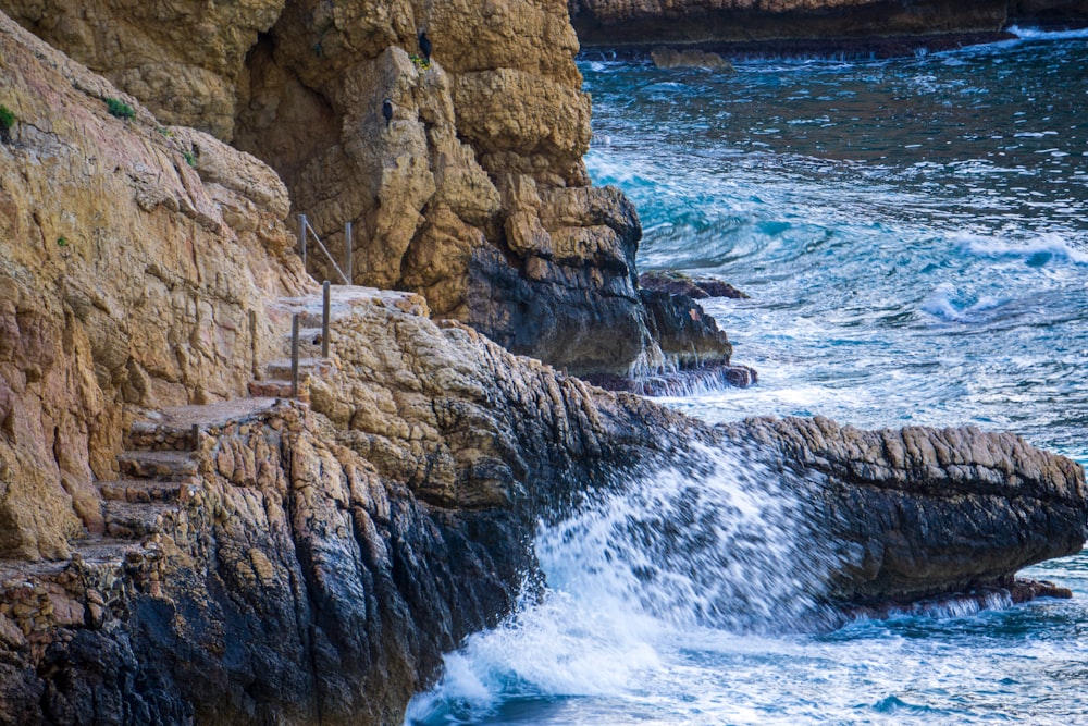 a person standing on a cliff next to the ocean