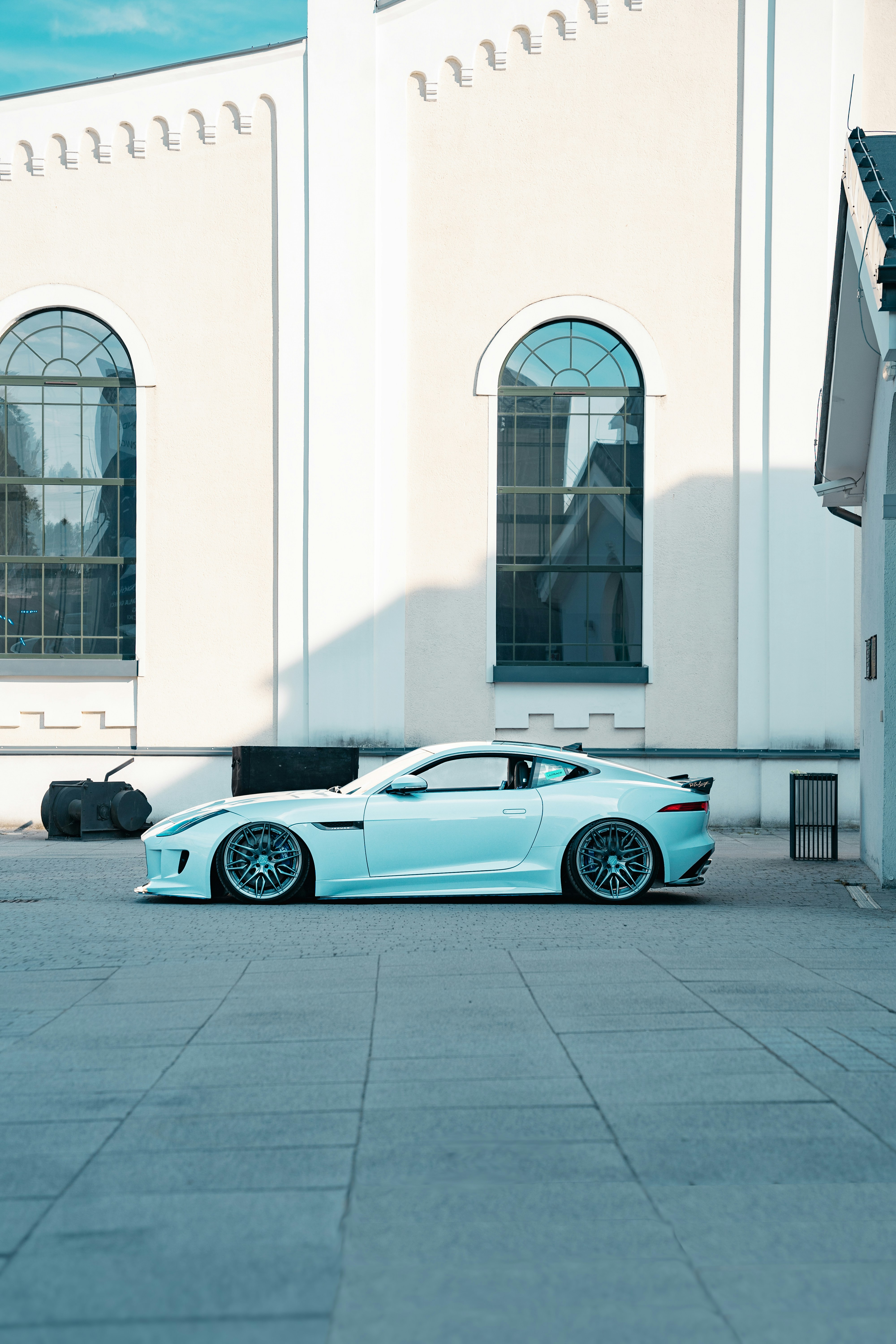 a blue sports car parked in front of a white building